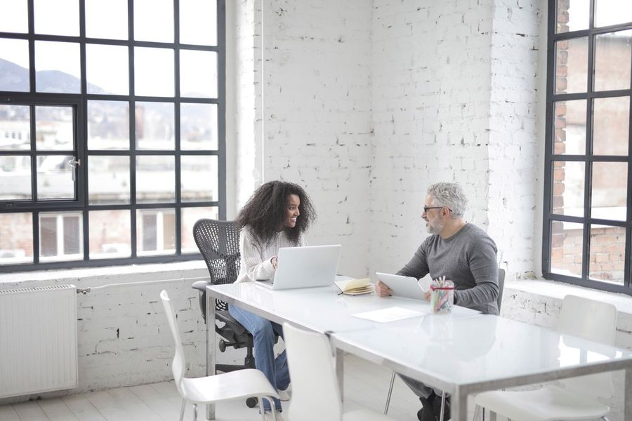 Two colleagues reviewing work together at a laptop